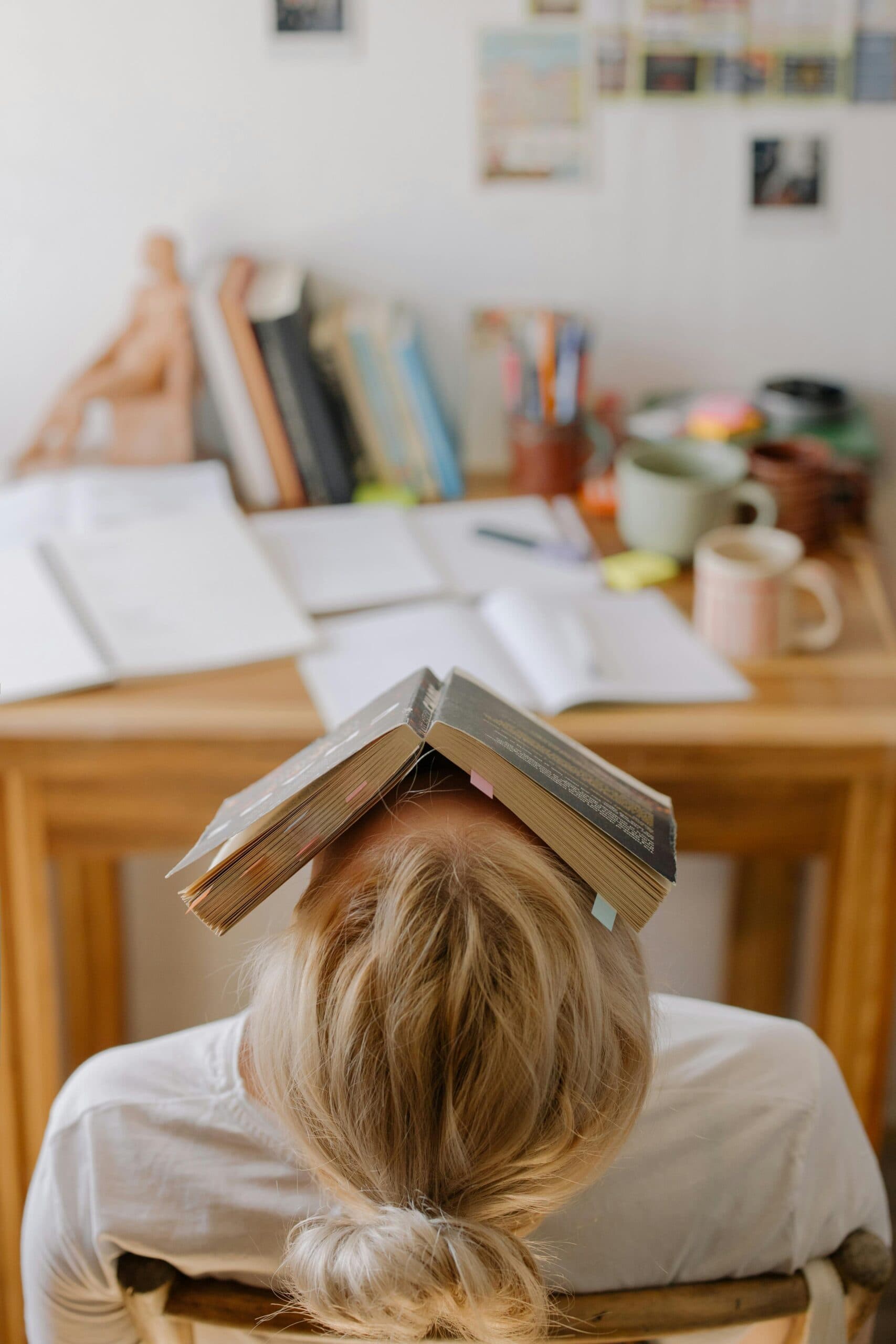 Estudiante con un libro abierto sobre su cabeza